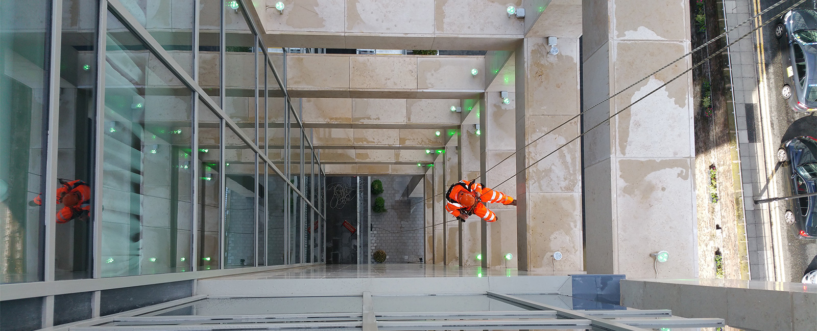 Photo showing a Rappel IRATA technician abseiling down a hotel in Manchester undertaking post construction snagging and cleaning works