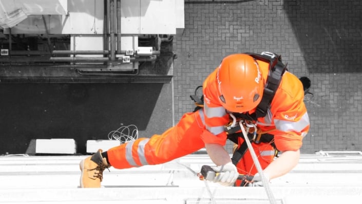 View of a Rappel rope access technician undertaking high level building maintenance works