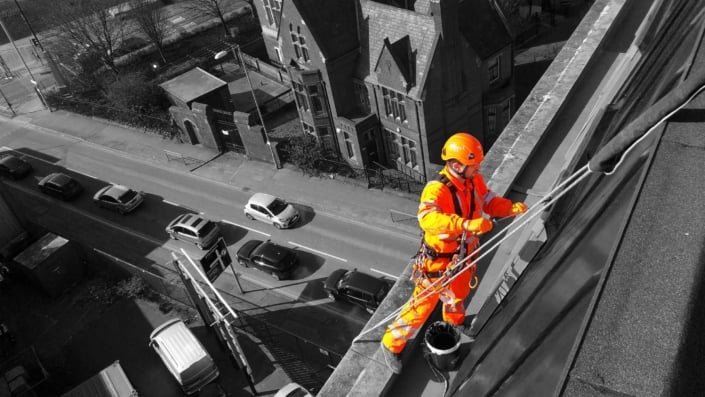 Rappel rope access technician undertaking high level building painting