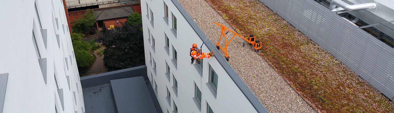 An IRATA Rope Access technician abseiling down a building