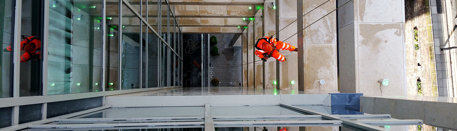 Rappel Rope Access technician abseiling down a building facade